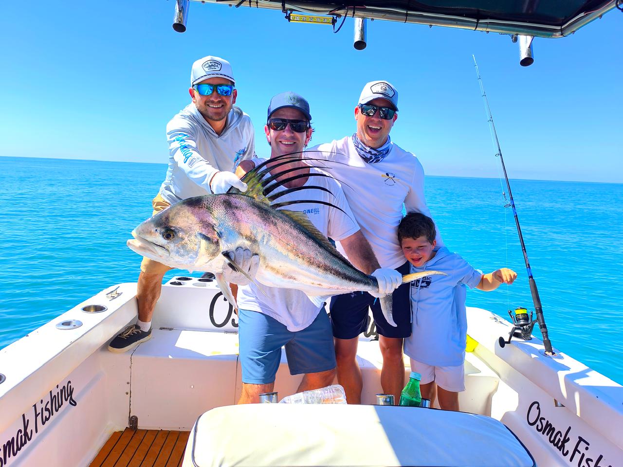 Family group with a massive roosterfish catch