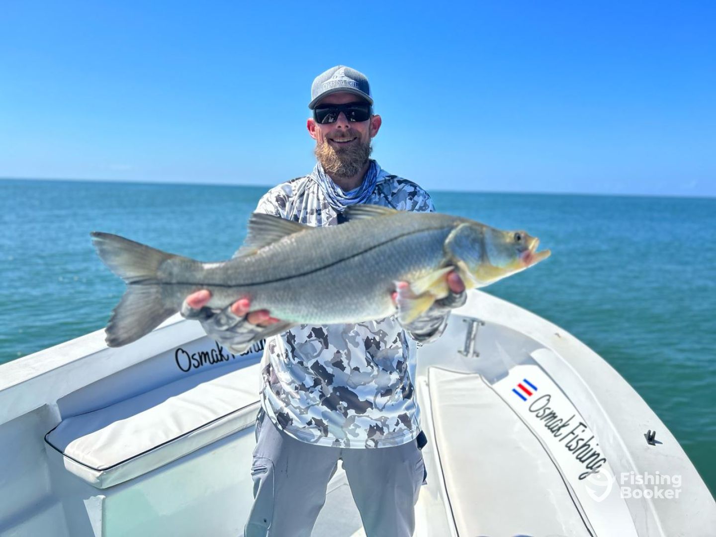 Angler with snook in calm turquoise waters