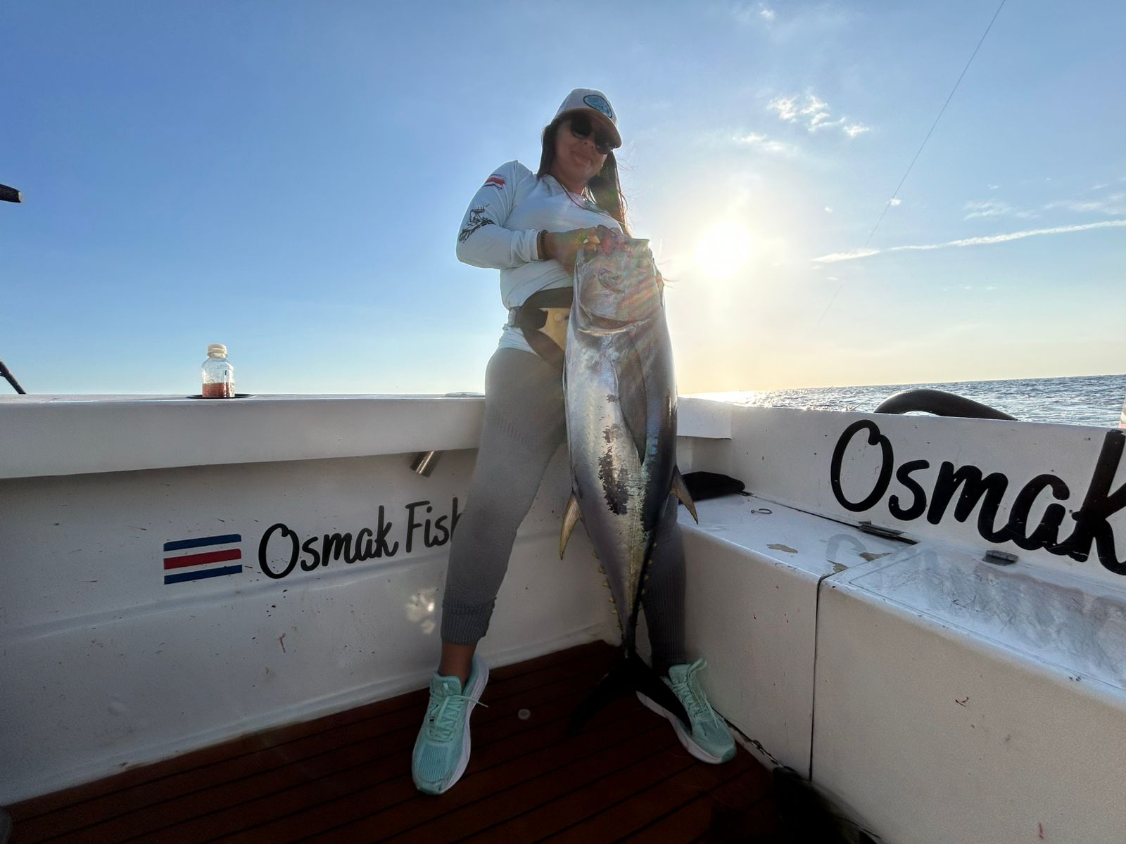 Woman with a big tuna catch at golden hour
